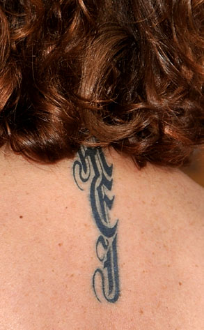  a tattoo on her neck. The initials stand for her three children's names.