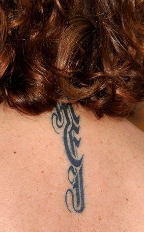 a tattoo on her neck. The initials stand for her three children's names.